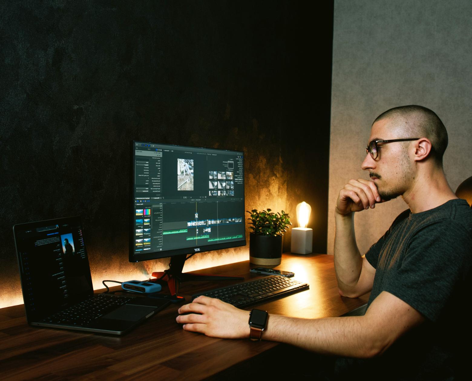 A video editor working on a timeline in DaVinci Resolve at a warm-lit desk