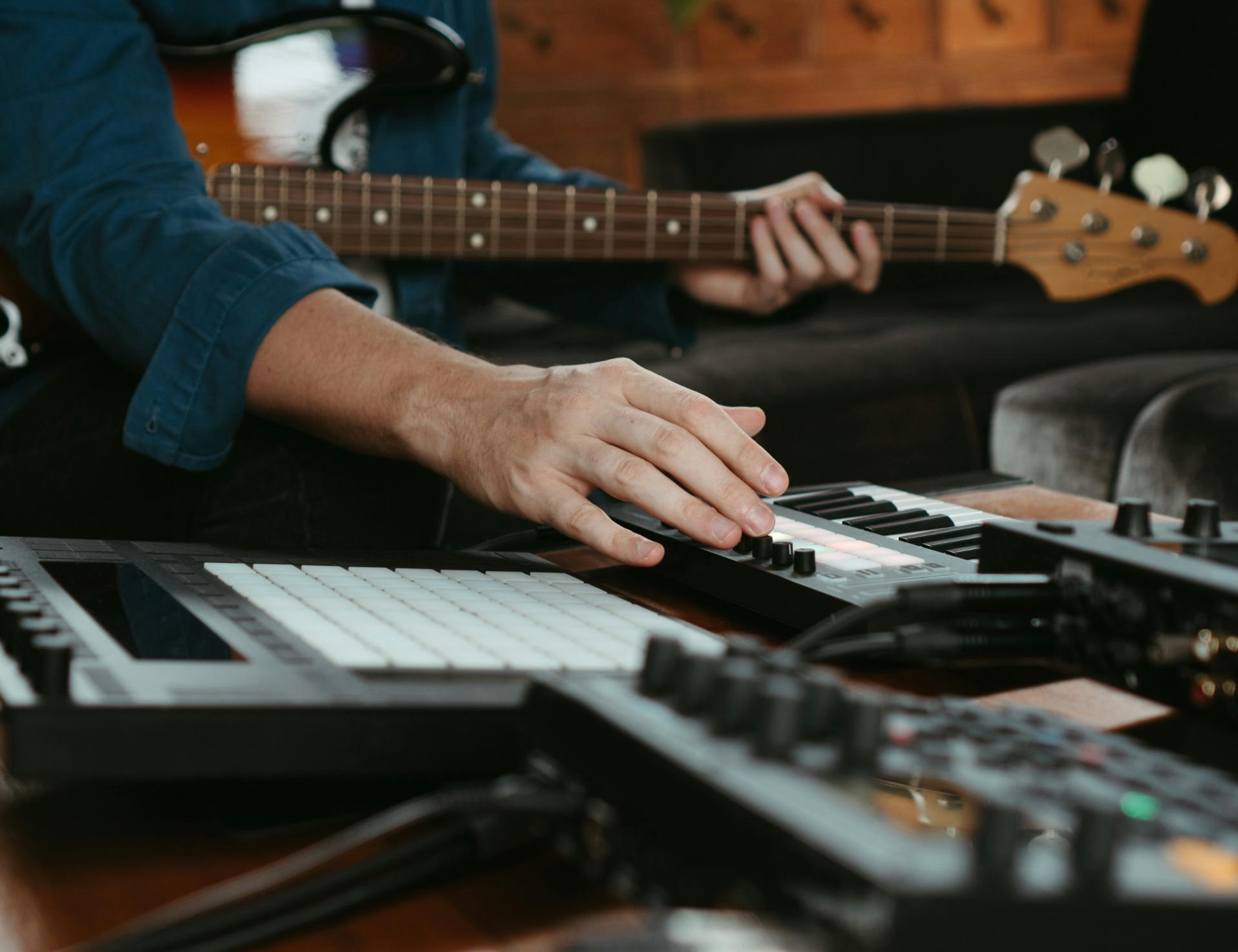 A microphone in front of audio production software on studio monitors