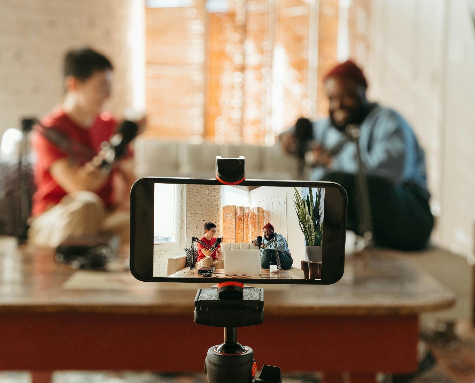 A creator filming over-the-shoulder at a warm-lit desk setup