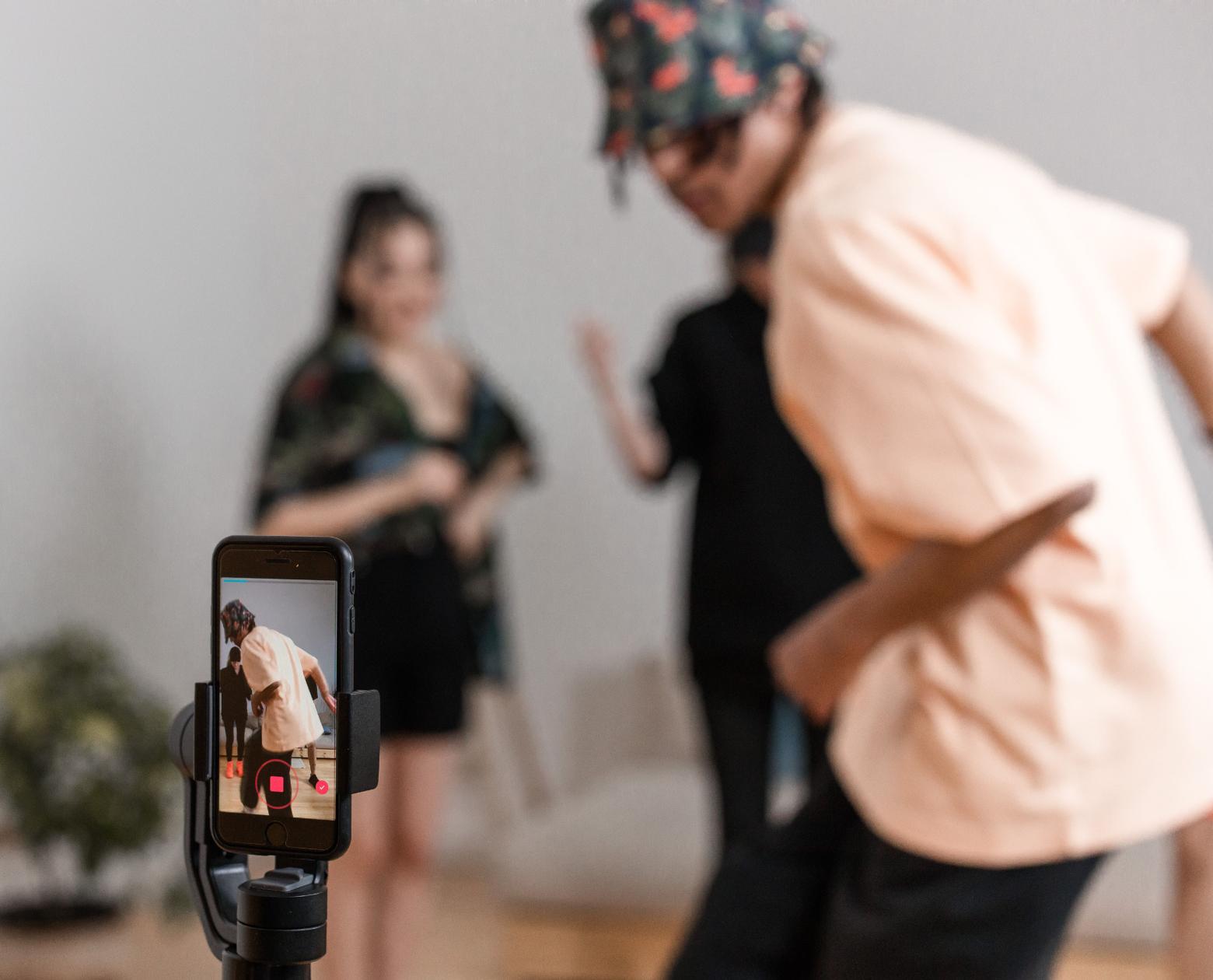 A phone on a small tripod with a ring light, set up for vertical filming
